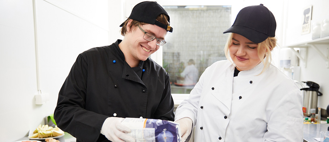 Zwei Personen arbeoten in der Küche