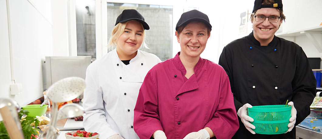 Drei Personen arbeiten in der Küche