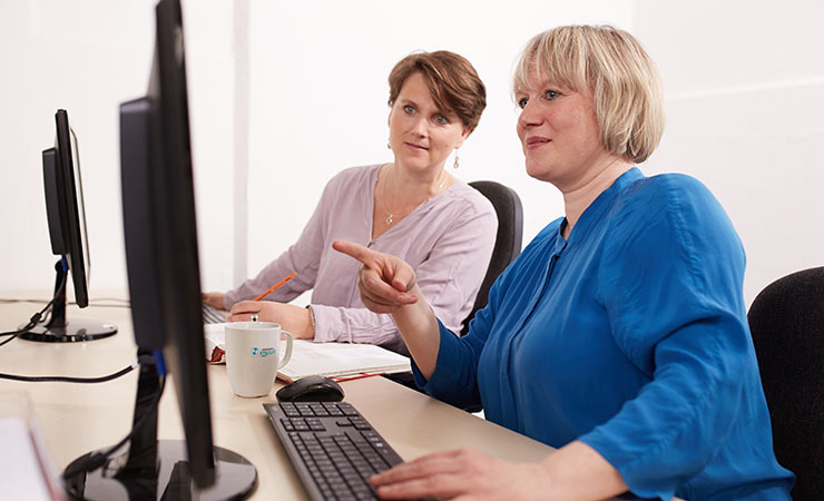 Zwei Frauen am Arbeitsplatz mit Computer