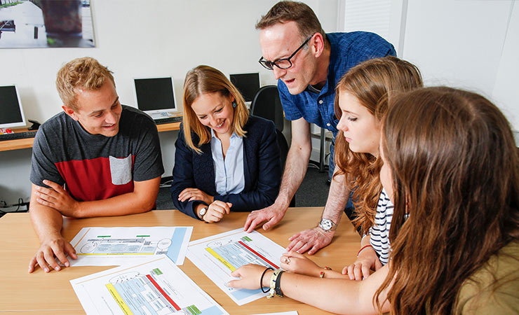 Mehrere Personen in einer Lehrsituation am Tisch